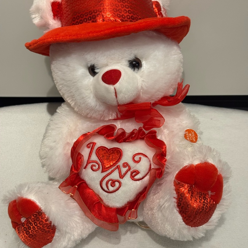 I Love You" musical teddy bear with a red sequin hat and heart.